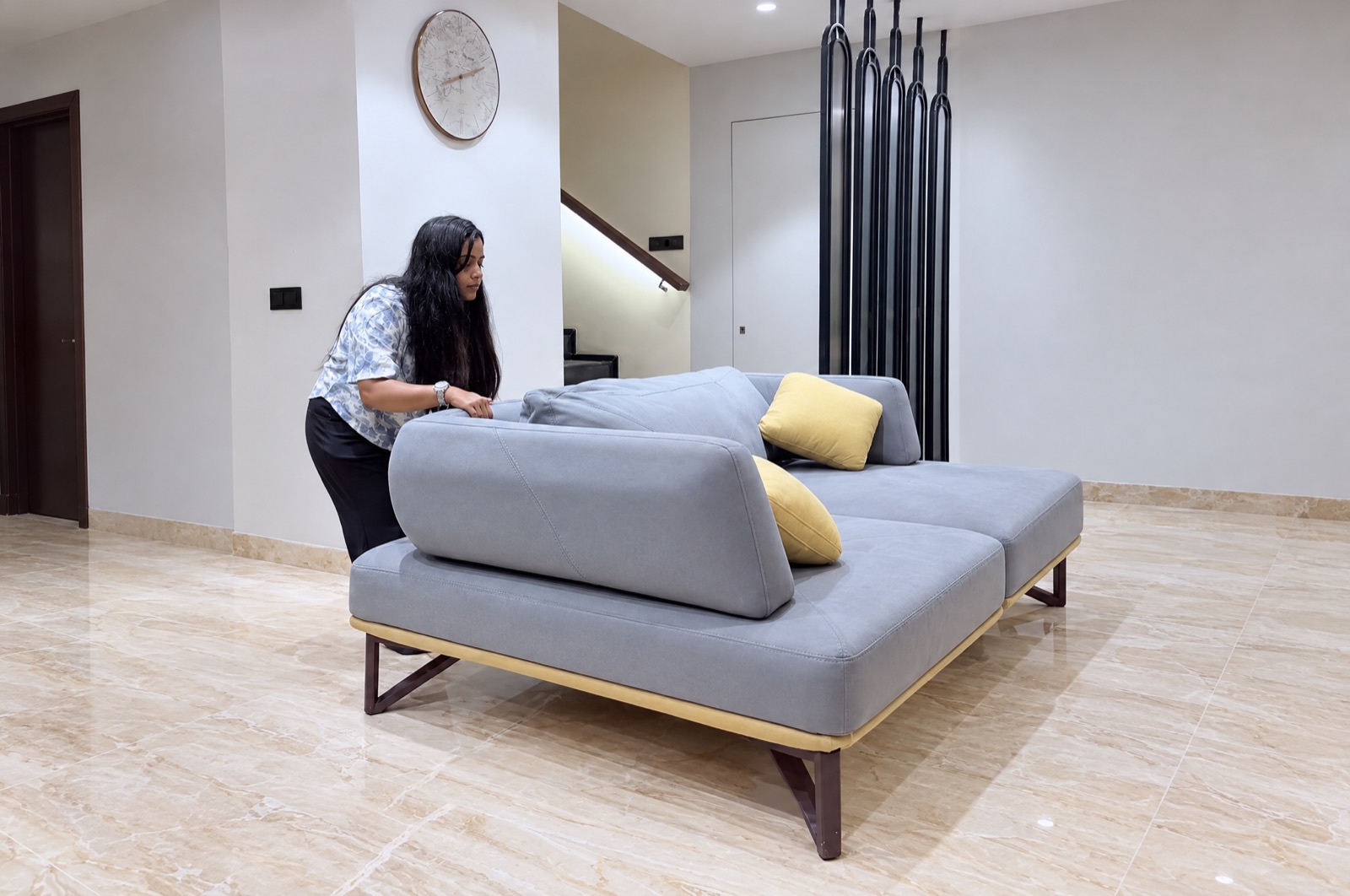 Surbhi arranging cushions on a sofa at Siesta Villa